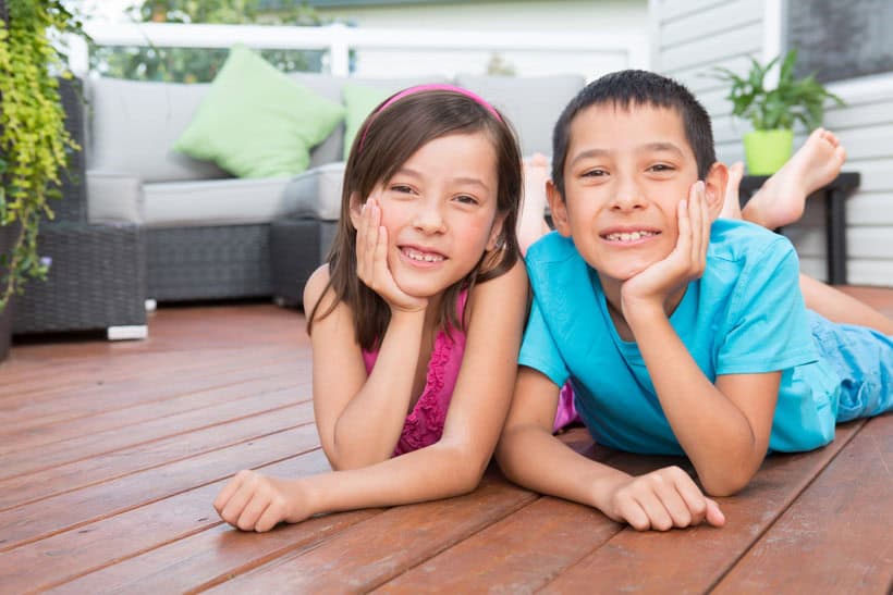 Smiling children laying on deck