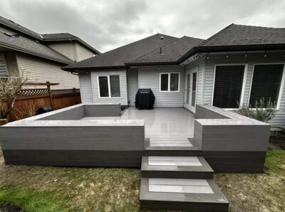 TruNorth decking in Ash Grey and Stone Grey to match the house exterior with a bench-style railing to enclose and provide seating.