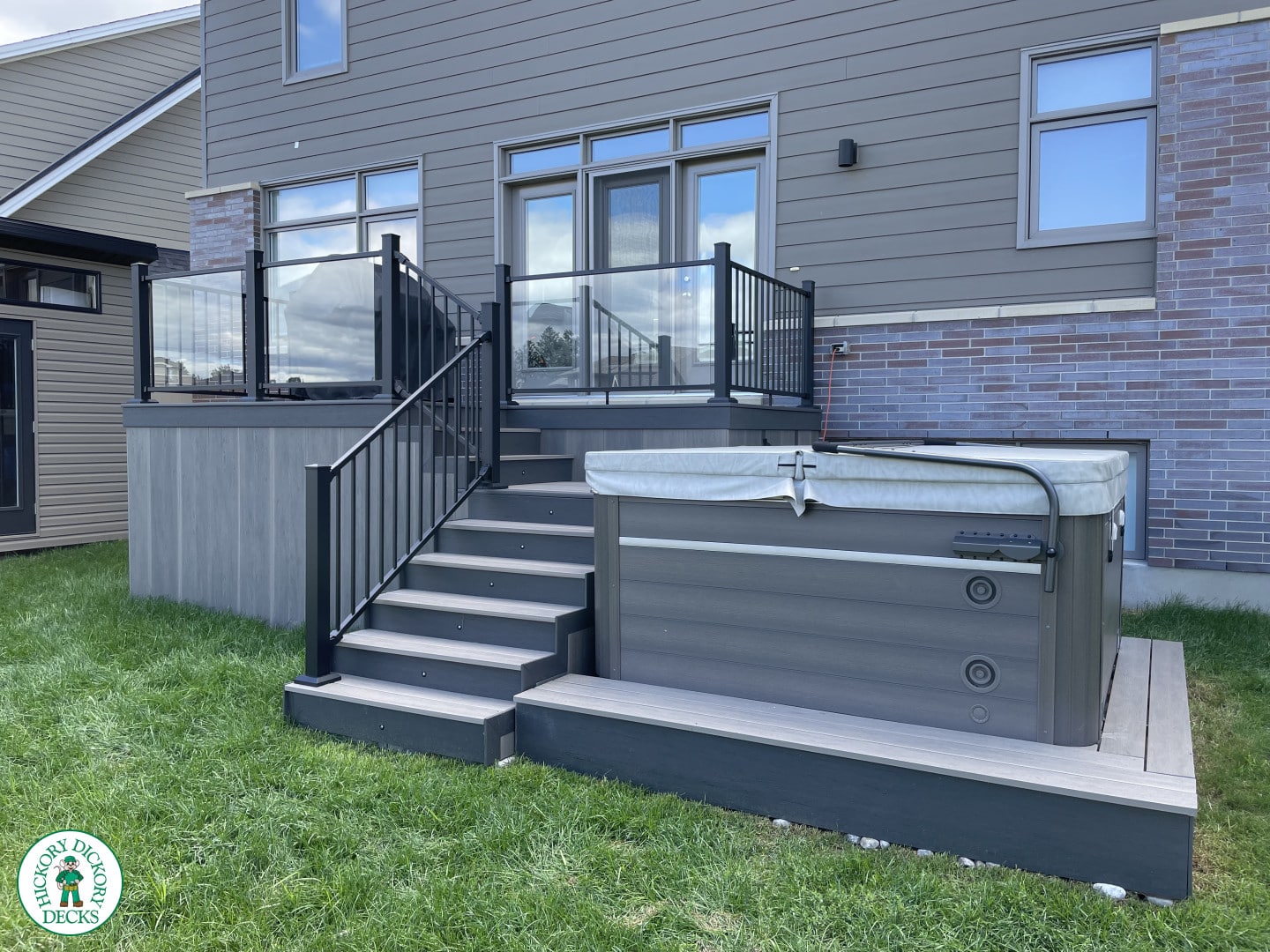 composite deck with glass railings and hottub